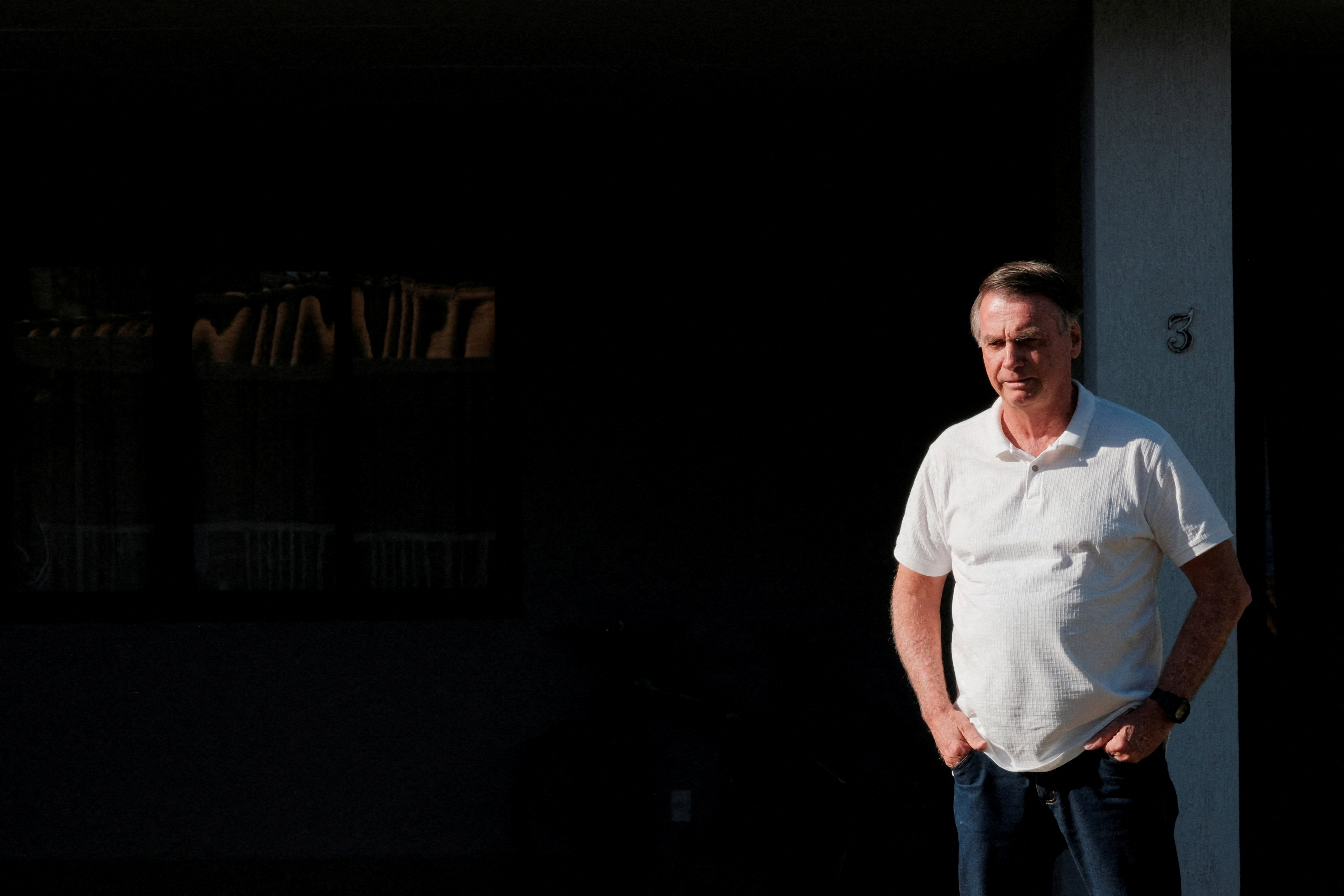O ex-presidente do Brasil, Jair Bolsonaro, observa de sua residência enquanto o governador de São Paulo, Tarcísio de Freitas (não mostrado), sai após uma visita em Brasília, Brasil, 29 de setembro de 2025. REUTERS/Diego Herculano