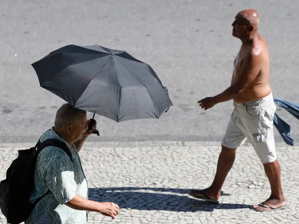 Rio de Janeiro (RJ), 26/12/2025 – Pessoas se protegem do sol no centro da cidade em dia de calor no Rio de Janeiro. Foto: Fernando Frazão/Agência Brasil