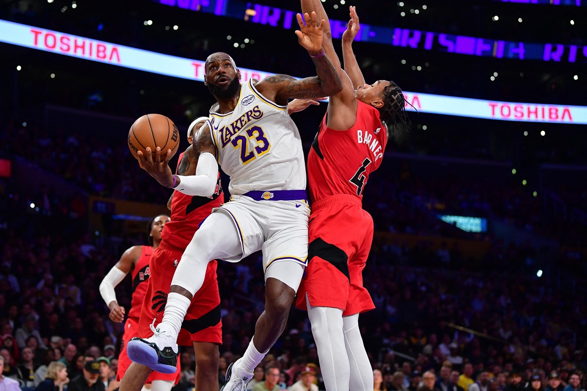 18 de janeiro de 2026; Los Angeles, Califórnia, EUA; o ala do Los Angeles Lakers, LeBron James (23), parte para a cesta contra o ala do Toronto Raptors, Scottie Barnes (4), durante o primeiro tempo na Crypto.com Arena. Crédito obrigatório: Gary A. Vasquez/Imagn Images.

