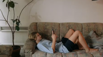 Imagem ilustrativa de um adolescente usando o celular