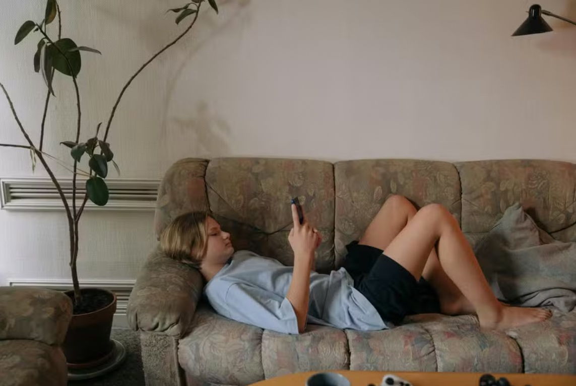 Imagem ilustrativa de um adolescente usando o celular
