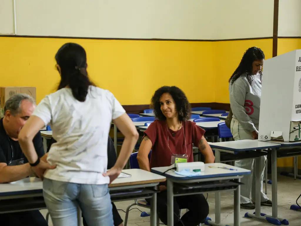Eleitores e mesários durante dia de votação das eleições