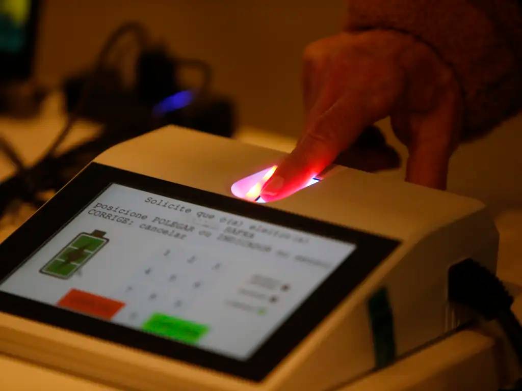 Dedo sobre urna eletrônica valida biometria no dia da votação