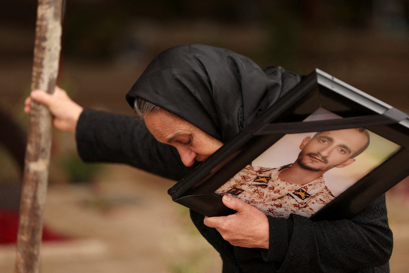 Mulher iraniana ao lado do túmulo do filho