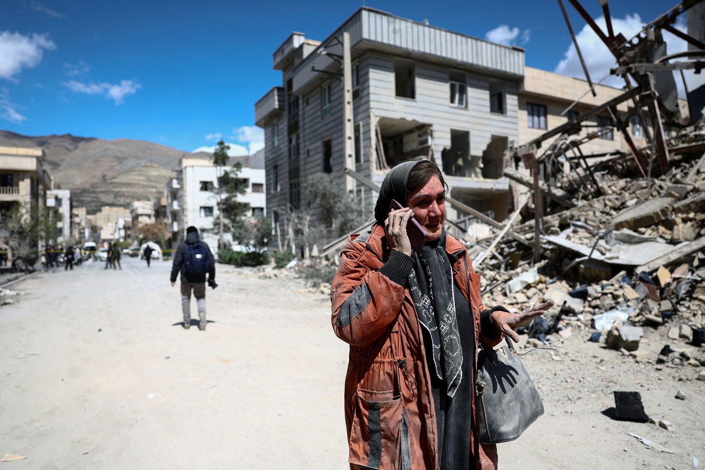 Mulher em meio a destroços de ataque Irã