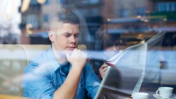 Profissional sentado em uma cafeteria adiando decisoes