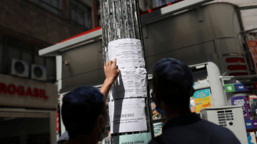 Pessoas observam anúncios de emprego em poste de luz no centro de São Paulo