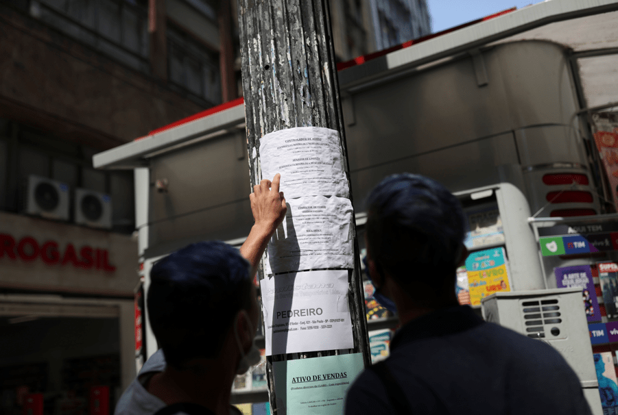 Pessoas observam anúncios de emprego em poste de luz no centro de São Paulo
