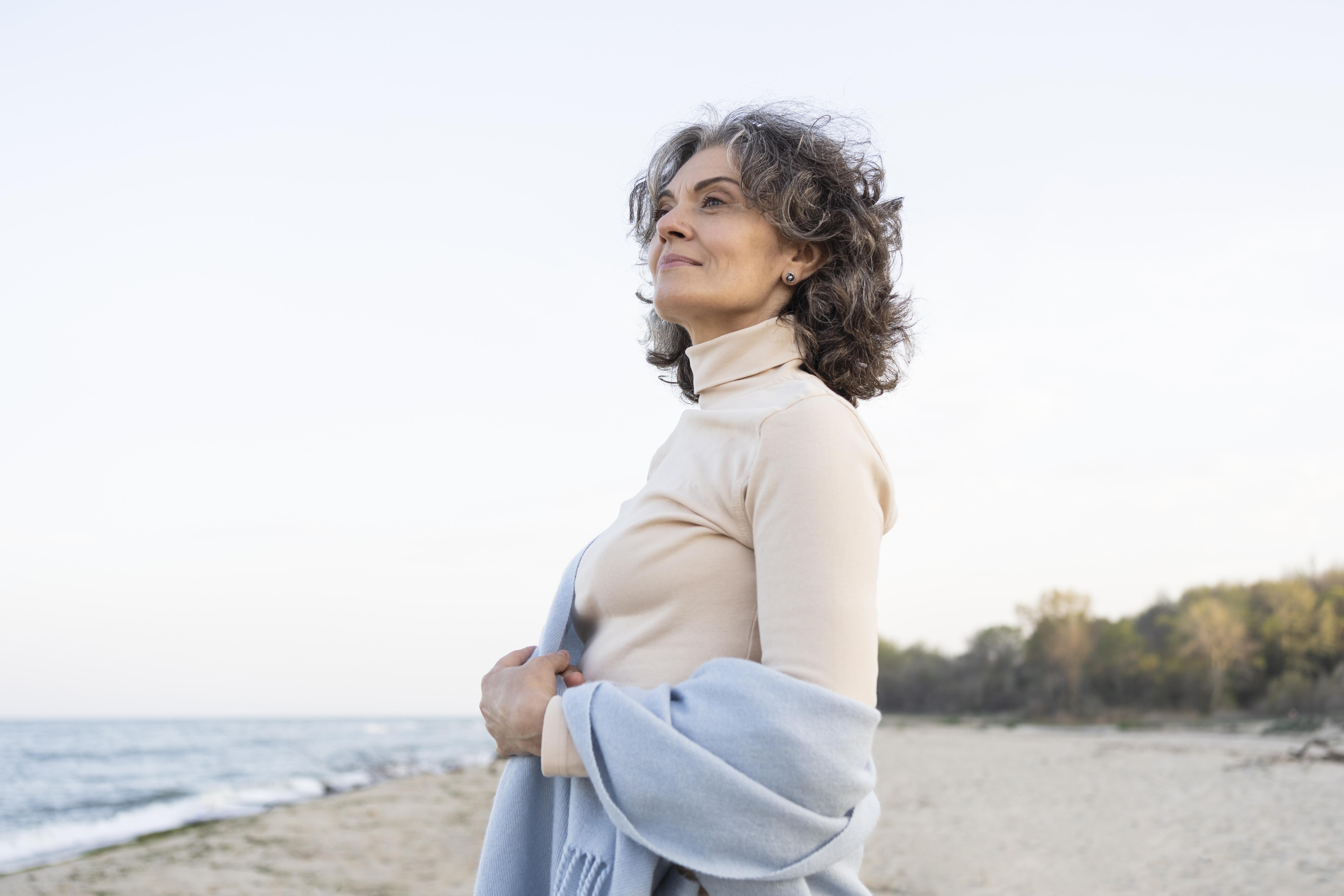 Longevidade em foco: como mulheres podem chegar aos 80 sem aperto financeiro 1 older woman enjoying her time beach
