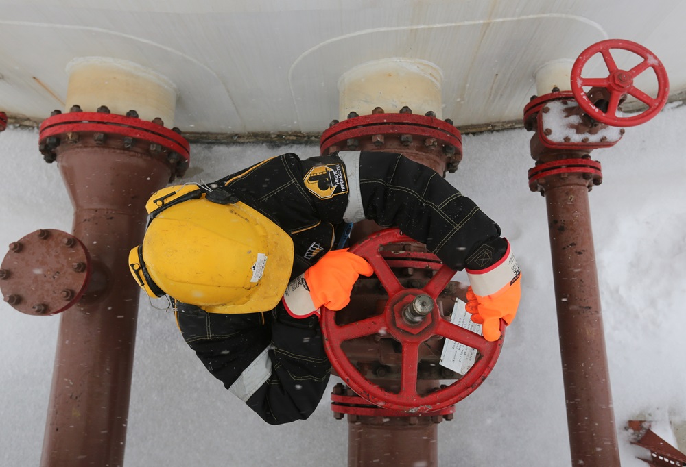 Um trabalhador gira uma válvula de controle na unidade de armazenamento de petróleo de Novokuibyshevsk, operada pela Rosneft PJSC, em Novokuibyshevsk, na região de Samara, Rússia, na quarta-feira, 21 de dezembro de 2016 (Andrey Rudakov/Bloomberg)