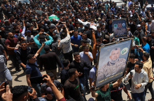 Pessoas carregam imagens e corpos identificados por enlutados como sendo do comandante da ala militar do Hamas, Izz al-Din al-Haddad, sua esposa e sua filha, mortos em um ataque israelense na sexta-feira