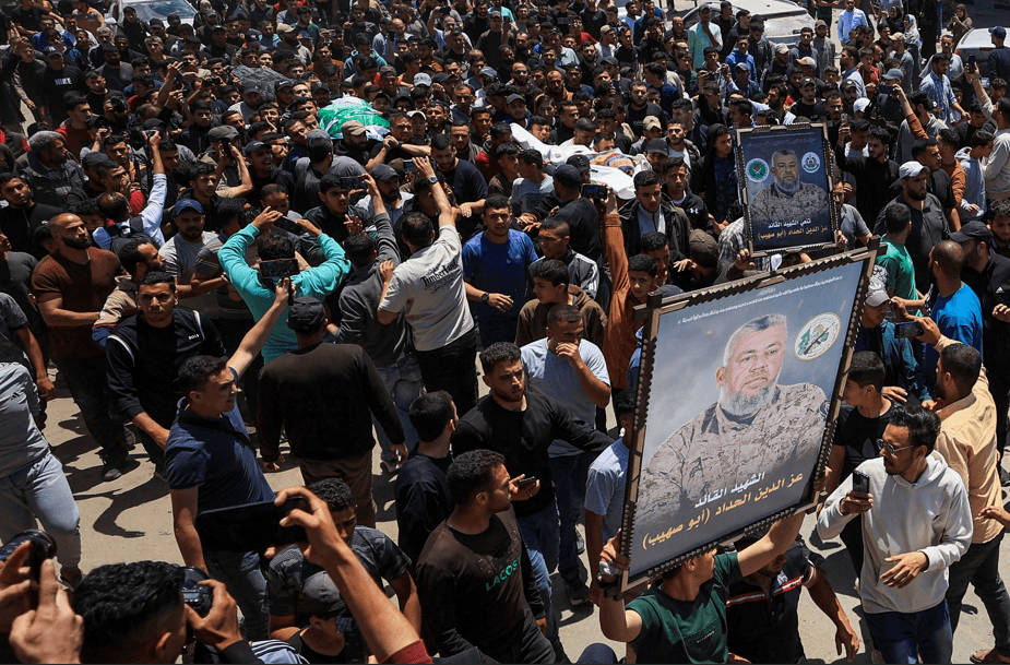 Pessoas carregam imagens e corpos identificados por enlutados como sendo do comandante da ala militar do Hamas, Izz al-Din al-Haddad, sua esposa e sua filha, mortos em um ataque israelense na sexta-feira
