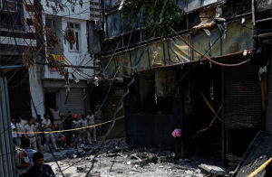 Bombeiros e policiais trabalham no local após um incêndio em um hotel em Nova Délhi, Índia, em 3 de junho de 2026.