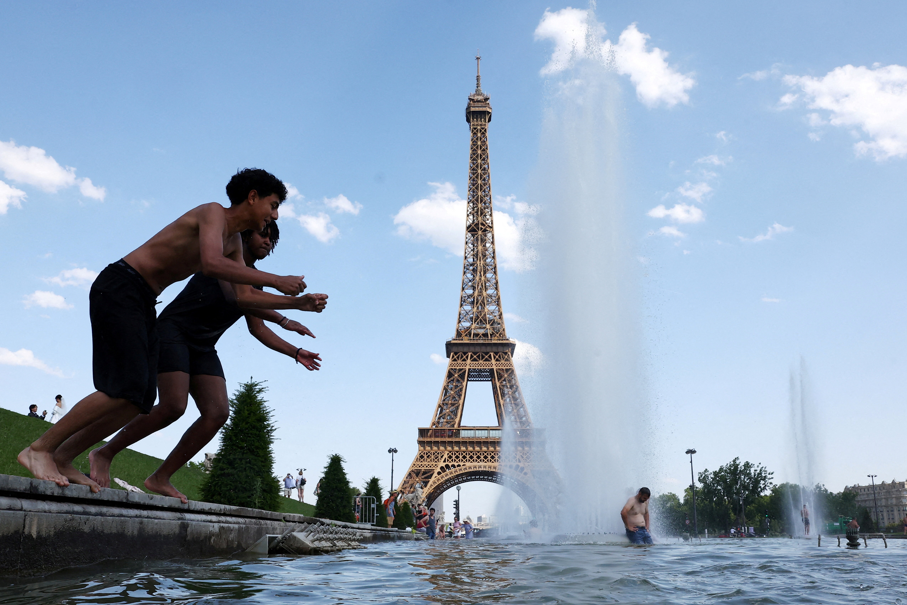 Pessoas se refrescam na Fonte do Trocadéro, ao lado da Torre Eiffel, em Paris, em meio a uma onda de calor que atinge grande parte da França, 22 de junho de 2026.