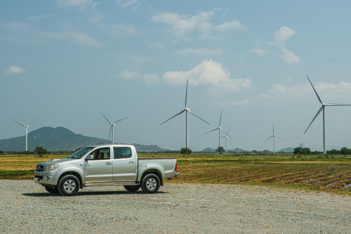 Veículo elétrico e turbinas eólicas ao fundo