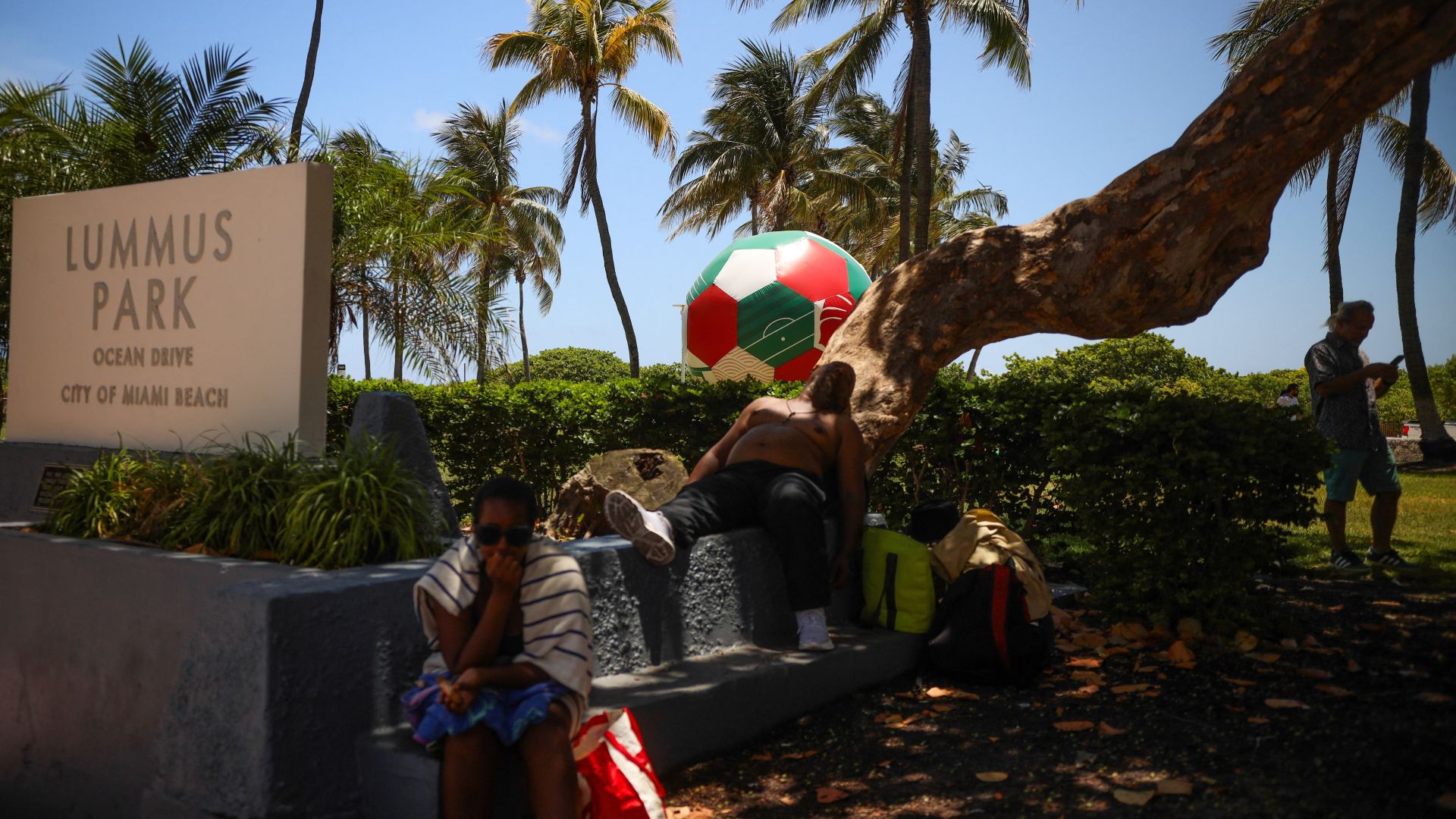Pessoas se protegem na sombra durante alerta de calor em Miami Beach em 17 de junho de 2026 (Foto: REUTERS/Maria Alejandra Cardona)