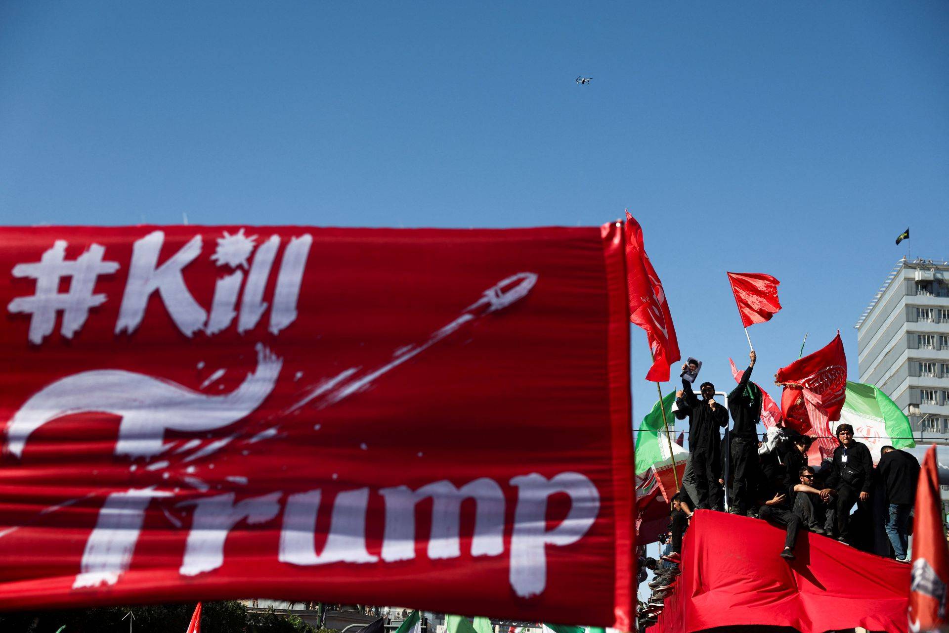 Cartaz contra o presidente dos EUA, Donald Trump, é erguido enquanto pessoas em luto se reúnem no dia do enterro do falecido líder supremo do Irã, aiatolá Ali Khamenei - 09/07/2026 (Foto: Majid Asgaripour/WANA -West Asia News Agency/via REUTERS)
