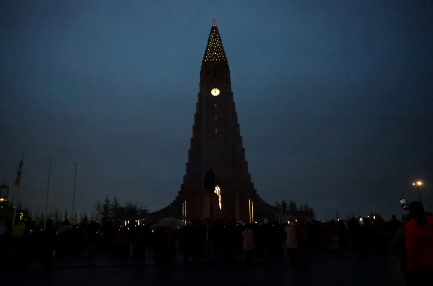 Pessoas se reúnem para observar o eclipse solar total, com nuvens cobrindo o céu, em Reykjavik, Islândia